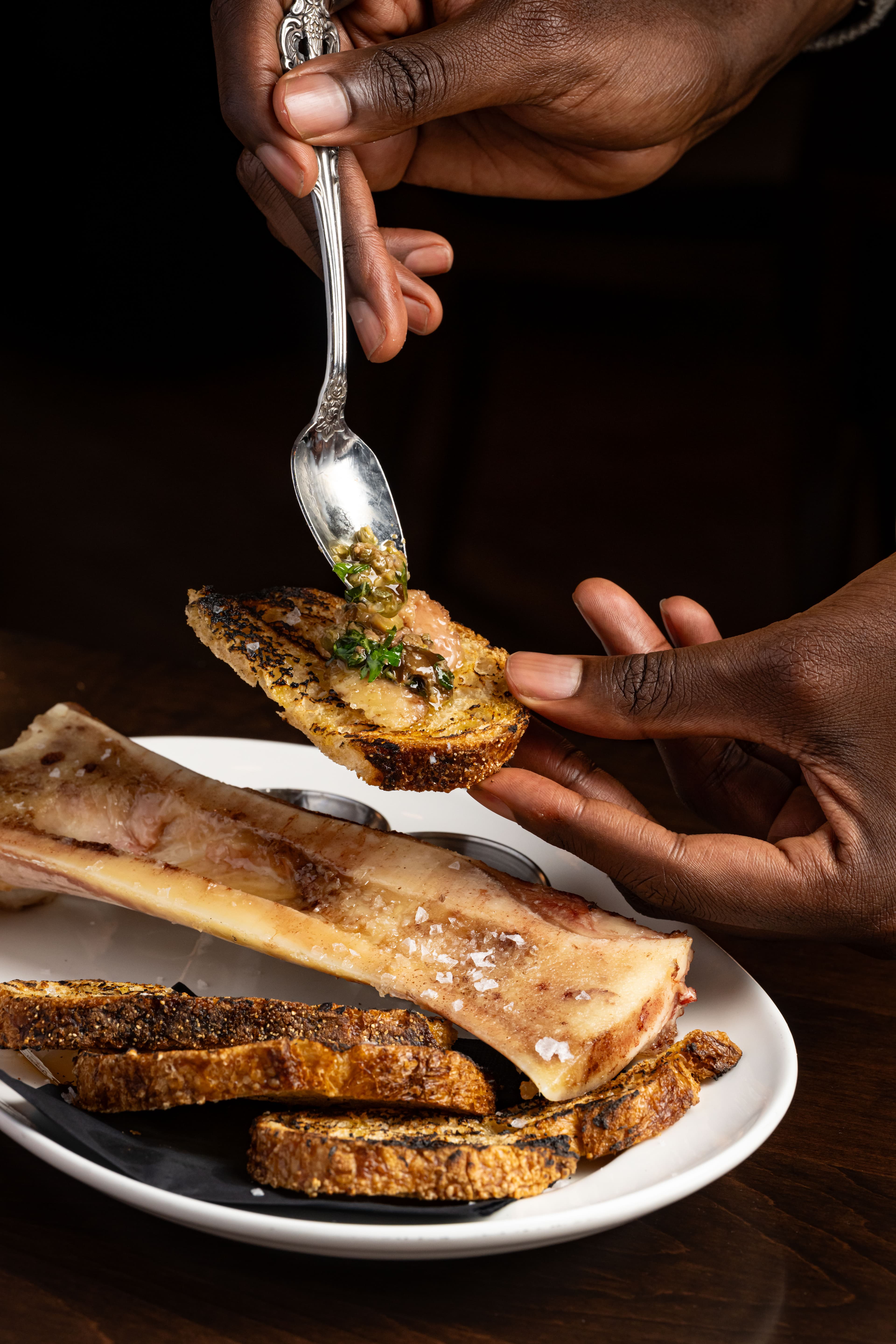 Roasted bone marrow with grilled sourdough, flaky sea salt, and herb salsa at The Berczy Tavern in Toronto