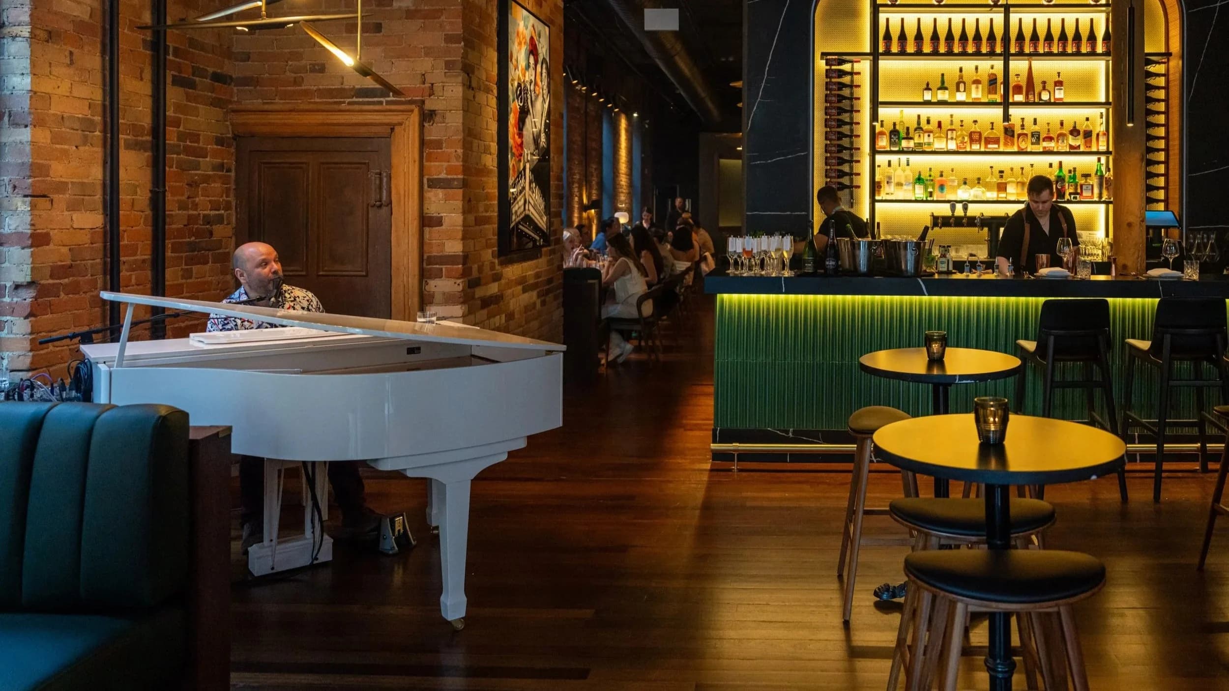 The white grand piano and dining room at The Berczy Tavern